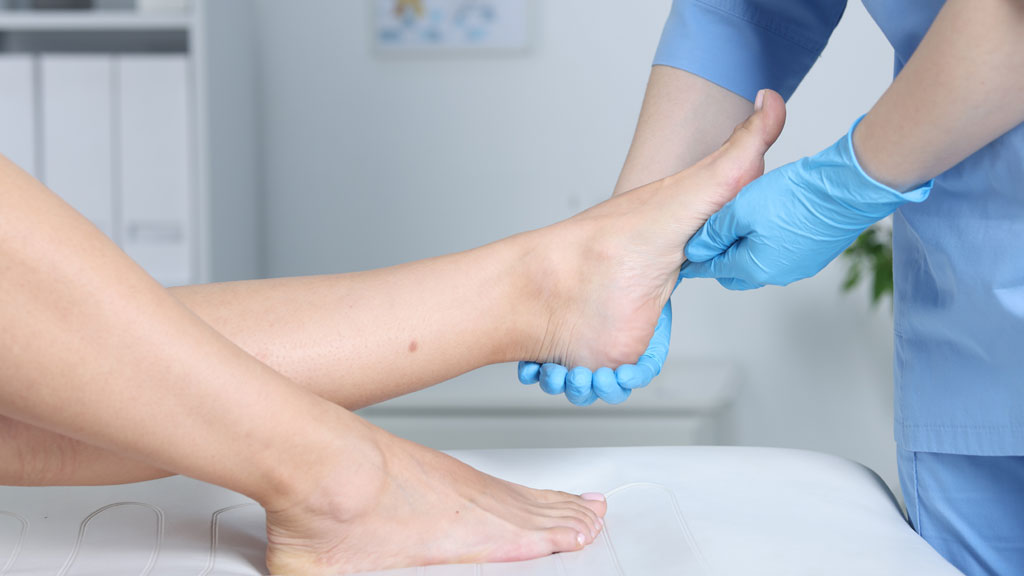 Patiente en convalescence à domicile avec pied surélevé et chaussure post-opératoire